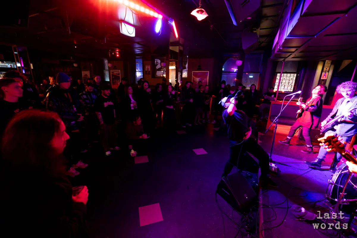 Band performing on last words stage with purple lighting